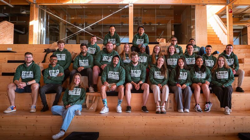 Groep jonge mensen met groene hoodies op een tribune