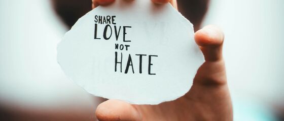 Tekst op papier "Share love not hate"