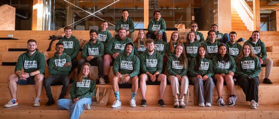 Groep jonge mensen met groene hoodies op een tribune
